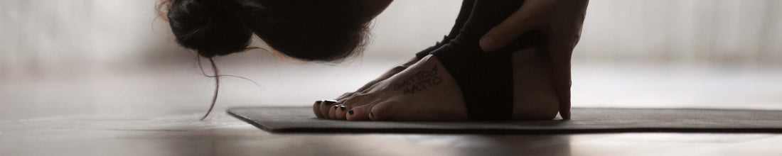  A person stretching on a black yoga mat